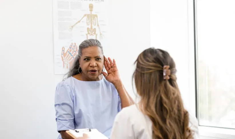 Audiologist speaking to patient during hearing exam