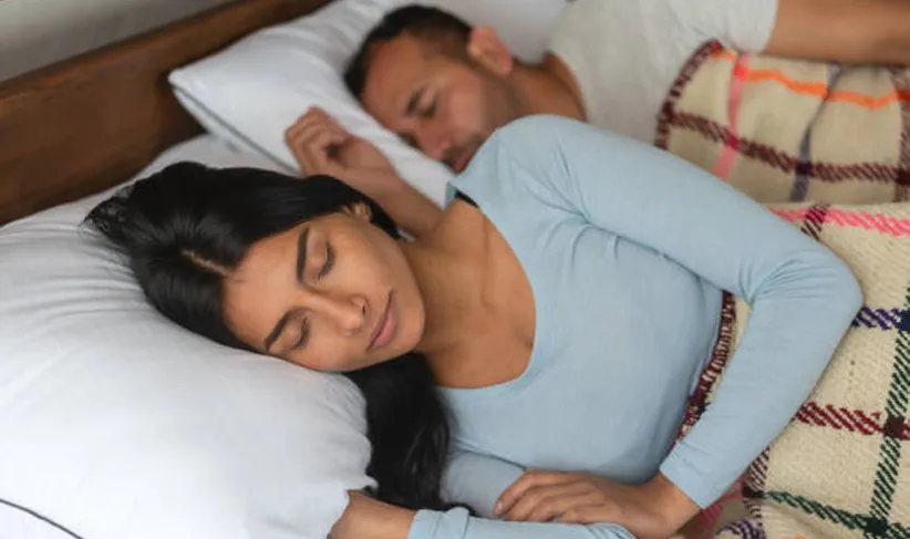 Couple comfortably sleeping in rustic bed